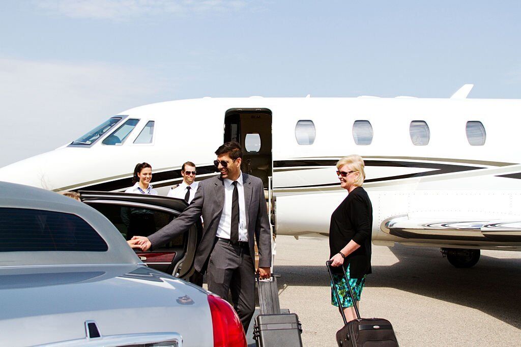 Lady being assisted by chauffeur out of car